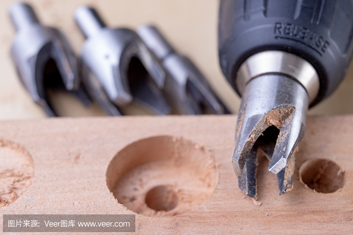 用专用钻在木工车间钻孔。用于修理工作的细木工配件。光背景。
